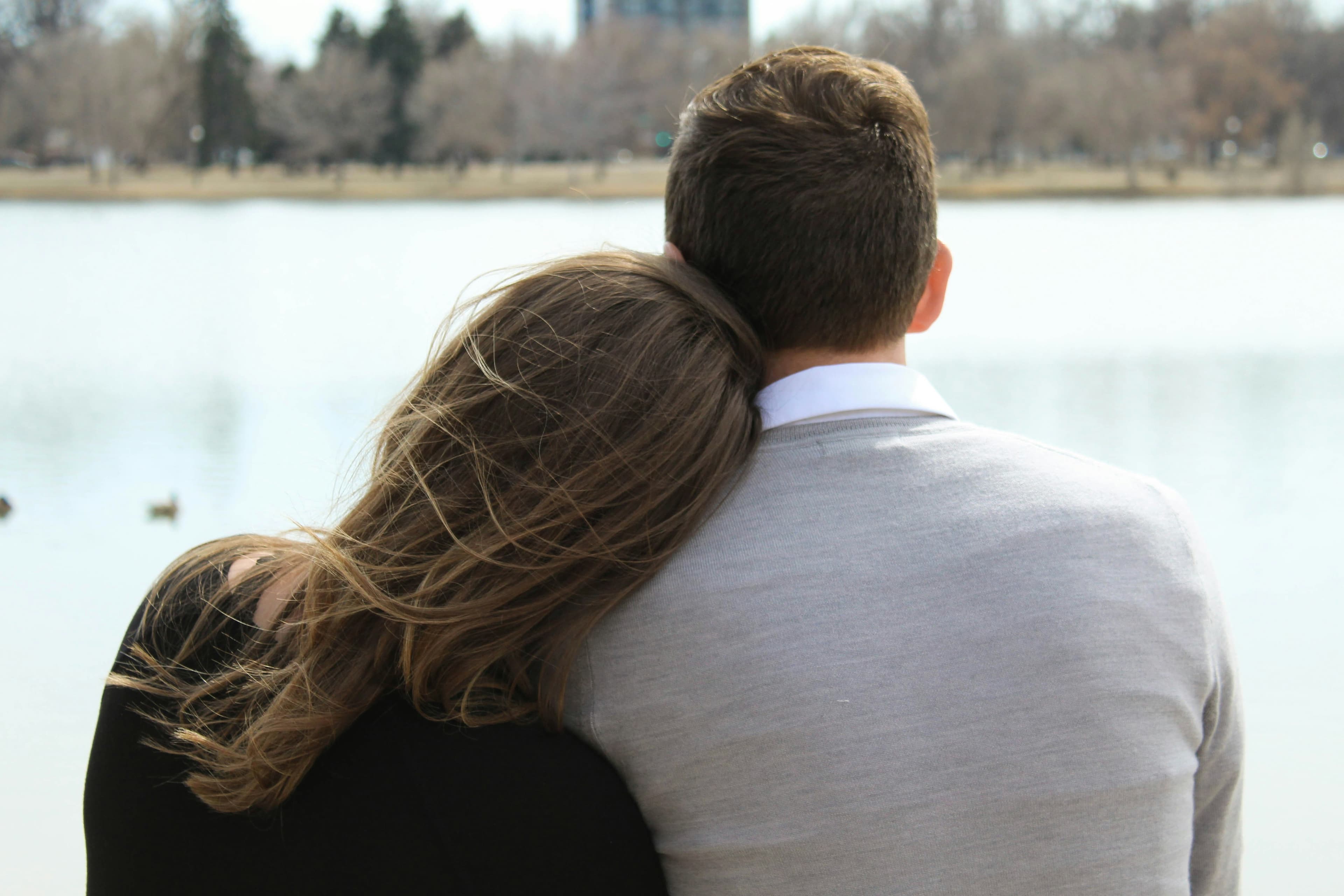 A couple sitting by a lake, taking the long view